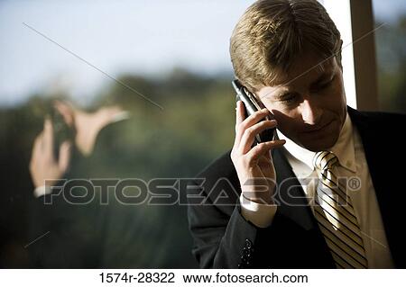 Businessman using mobile phone in an office View Large Photo Image Stock Image - Businessman using mobile phone in an office. Fotosearch