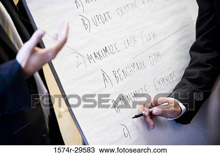 Businessman writing on board in an office View Large Photo Image Stock Image - Businessman writing on board in an office. Fotosearch