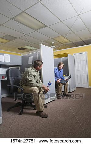 Businessmen conversing in an office View Large Photo Image Stock Image - Businessmen conversing in an office. Fotosearch