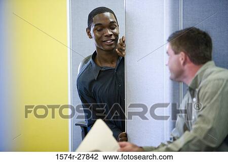 Businessmen conversing in an office View Large Photo Image Stock Image - Businessmen conversing in an office. Fotosearch