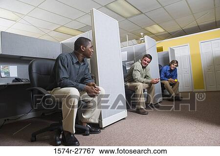 Businessmen conversing in an office View Large Photo Image Stock Photo - Businessmen conversing in an office. Fotosearch