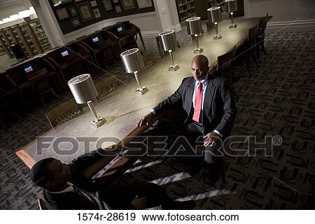 Businessmen conversing in an office View Large Photo Image Stock Photo - Businessmen conversing in an office. Fotosearch