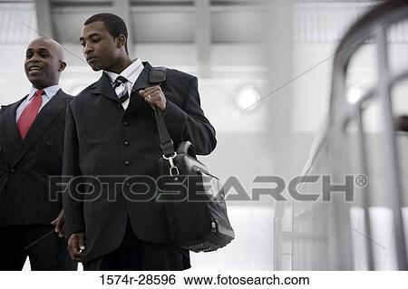 Stock Photograph - Businessmen conversing in an office. Fotosearch