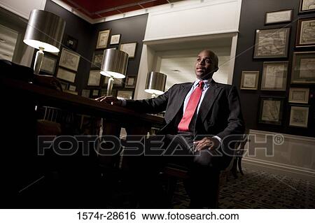 Businessmen conversing in an office View Large Photo Image Stock Photograph - Businessmen conversing in an office. Fotosearch