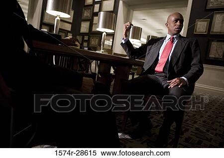 Businessmen conversing in an office View Large Photo Image Stock Photography - Businessmen conversing in an office. Fotosearch