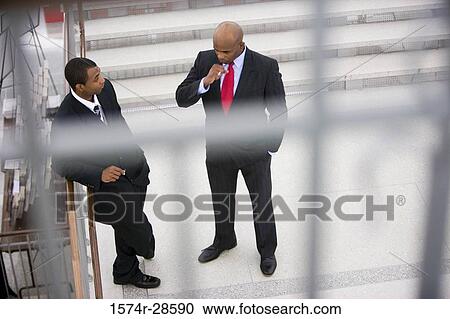 Businessmen conversing on staircase View Large Photo Image Stock Image - Businessmen conversing on staircase. Fotosearch