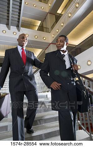 Businessmen descending on staircase in an office View Large Photo Image Picture - Businessmen descending on staircase in an office. Fotosearch