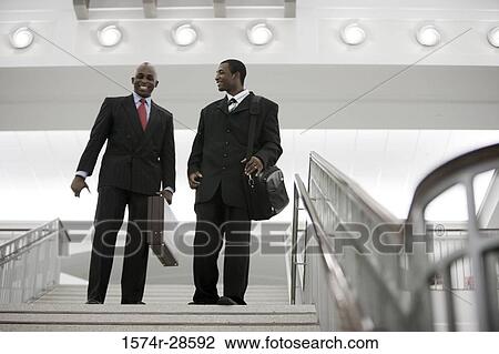 Businessmen descending on staircase in an office View Large Photo Image Stock Image - Businessmen descending on staircase in an office. Fotosearch