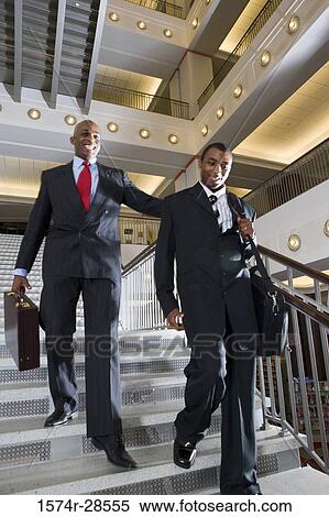 Businessmen descending on staircase in an office View Large Photo Image Stock Photography - Businessmen descending on staircase in an office. Fotosearch