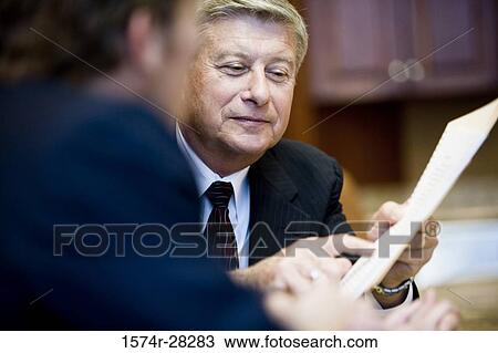 Stock Image - Businessmen discussing in an office. Fotosearch