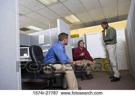 Stock Photo - Businessmen in conversation using chart board in an office. Fotosearch