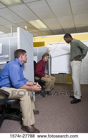 Businessmen in conversation using chart board in an office View Large Photo Image Stock Photo - Businessmen in conversation using chart board in an office. Fotosearch
