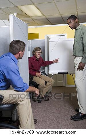 Businessmen in conversation using chart board in an office View Large Photo Image Stock Photo - Businessmen in conversation using chart board in an office. Fotosearch