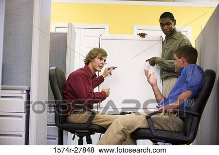Stock Photo - Businessmen in conversation using chart board in an office. Fotosearch