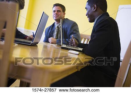 Businessmen in full suit conversing in an office View Large Photo Image Stock Photo - Businessmen in full suit conversing in an office. Fotosearch
