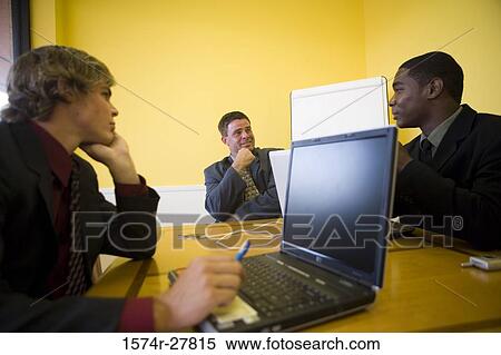 Stock Photography - Businessmen in full suit conversing in an office. Fotosearch