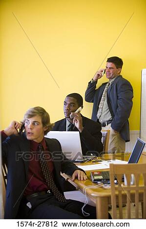 Businessmen in full suit using mobile phone and laptop in an office View Large Photo Image Stock Image - Businessmen in full suit using mobile phone and laptop in an office. Fotosearch