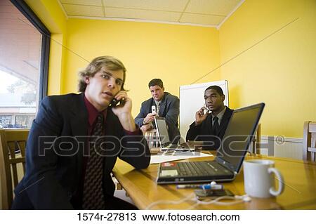 Businessmen in full suit using mobile phone and laptop in an office View Large Photo Image Stock Image - Businessmen in full suit using mobile phone and laptop in an office. Fotosearch