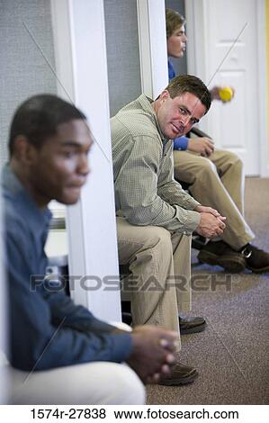 Stock Photo - Businessmen sitting in an office. Fotosearch