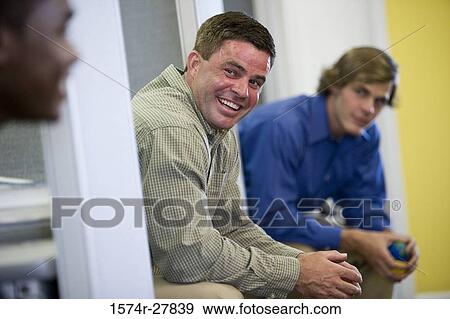 Businessmen smiling in an office View Large Photo Image Stock Photo - Businessmen smiling in an office. Fotosearch