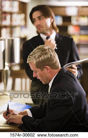 Stock Image - Businessmen working in an office. Fotosearch