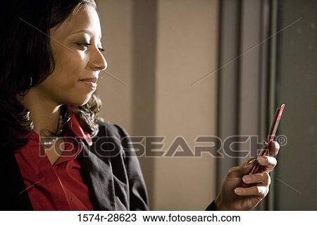 Businesswoman looking a mobile phone View Large Photo Image Stock Image - Businesswoman looking a mobile phone. Fotosearch