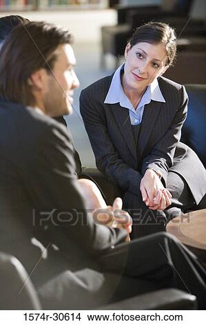 Businesswoman looking businessman and smiling in an office View Large Photo Image Picture - Businesswoman looking businessman and smiling in an office. Fotosearch