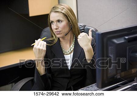 Businesswoman sitting in front of computer in an office View Large Photo Image Stock Image - Businesswoman sitting in front of computer in an office. Fotosearch