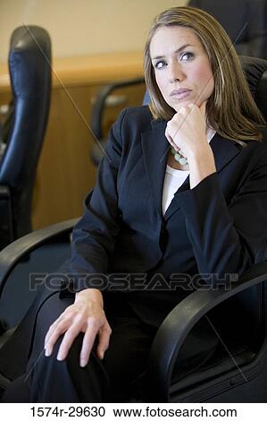 Businesswoman sitting on armchair and looking up in an office View Large Photo Image Stock Image - Businesswoman sitting on armchair and looking up in an office. Fotosearch