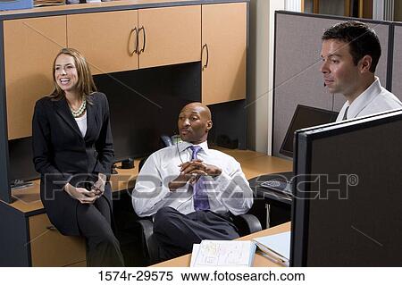 Businesswoman smiling by colleagues in an office View Large Photo Image Stock Photography - Businesswoman smiling by colleagues in an office. Fotosearch
