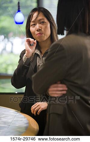 Businesswoman talking with a colleague in an office View Large Photo Image Stock Photograph - Businesswoman talking with a colleague in an office. Fotosearch