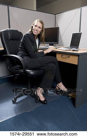 Stock Image - Businesswoman using computer in an office. Fotosearch