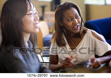 Stock Image - Businesswomen sitting in office. Fotosearch