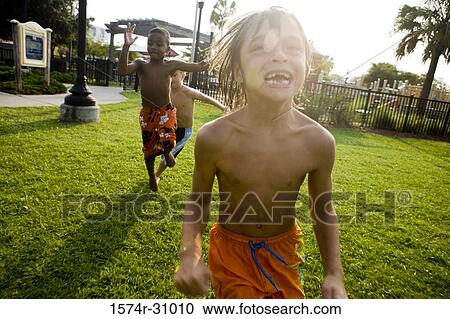 Cheerful bare chested boys playing on grass View Large Photo Image Stock Image - Cheerful bare chested boys playing on grass. Fotosearch