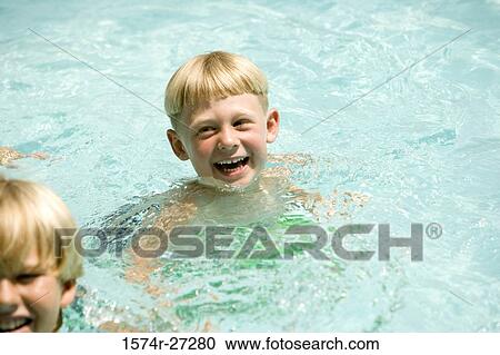 Cheerful boys swimming in swimming pool View Large Photo Image Stock Image - Cheerful boys swimming in swimming pool. Fotosearch