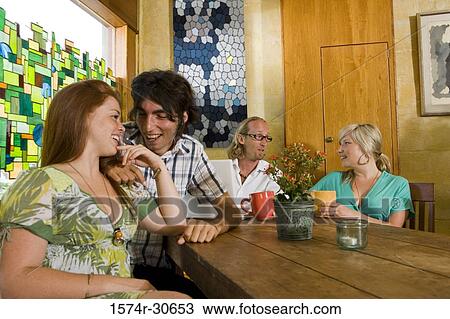 Cheerful brother and sister sitting with parent by a table View Large Photo Image Stock Image - Cheerful brother and sister sitting with parent by a table. Fotosearch