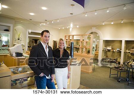 Stock Image - Cheerful couple standing together in a store. Fotosearch