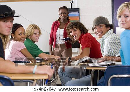 Cheerful female teacher teaching students in the classroom View Large Photo Image Stock Photo - Cheerful female teacher teaching students in the classroom. Fotosearch
