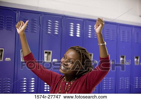 Cheerful female teacher with arms raised by lockers View Large Photo Image Stock Photo - Cheerful female teacher with arms raised by lockers. Fotosearch