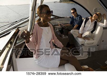 Cheerful friends enjoying in the boat View Large Photo Image Stock Photo - Cheerful friends enjoying in the boat. Fotosearch