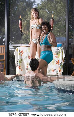 Cheerful friends in swimwear at swimming pool View Large Photo Image Stock Photo - Cheerful friends in swimwear at swimming pool. Fotosearch