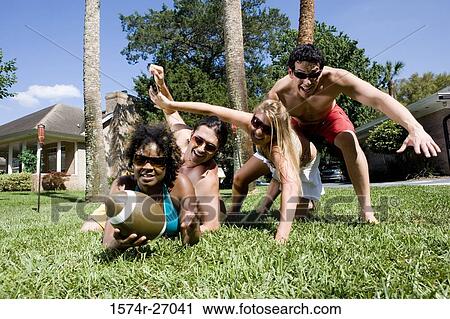 Cheerful friends playing touch football on lawn View Large Photo Image Stock Image - Cheerful friends playing touch football on lawn. Fotosearch