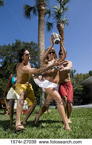 Cheerful friends playing touch football on lawn View Large Photo Image Stock Photo - Cheerful friends playing touch football on lawn. Fotosearch