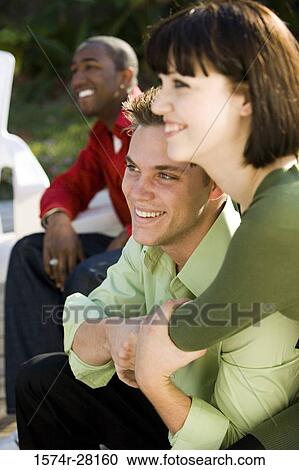 Cheerful friends sitting on armchairs View Large Photo Image Stock Image - Cheerful friends sitting on armchairs. Fotosearch