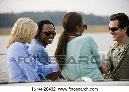 Cheerful friends sitting together View Large Photo Image Stock Image - Cheerful friends sitting together. Fotosearch