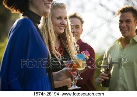 Cheerful friends with drinks outdoors View Large Photo Image Picture - Cheerful friends with drinks outdoors. Fotosearch