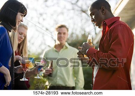 Cheerful friends with drinks outdoors View Large Photo Image Stock Image - Cheerful friends with drinks outdoors. Fotosearch