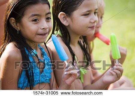 Cheerful girls eating flavored ice View Large Photo Image Stock Photography - Cheerful girls eating flavored ice. Fotosearch