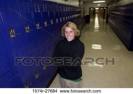 Cheerful male student standing by lockers in corridor View Large Photo Image Picture - Cheerful male student standing by lockers in corridor. Fotosearch