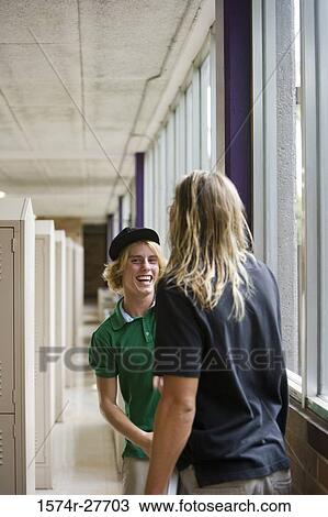 Cheerful male students standing by locker in corridor View Large Photo Image Stock Image - Cheerful male students standing by locker in corridor. Fotosearch